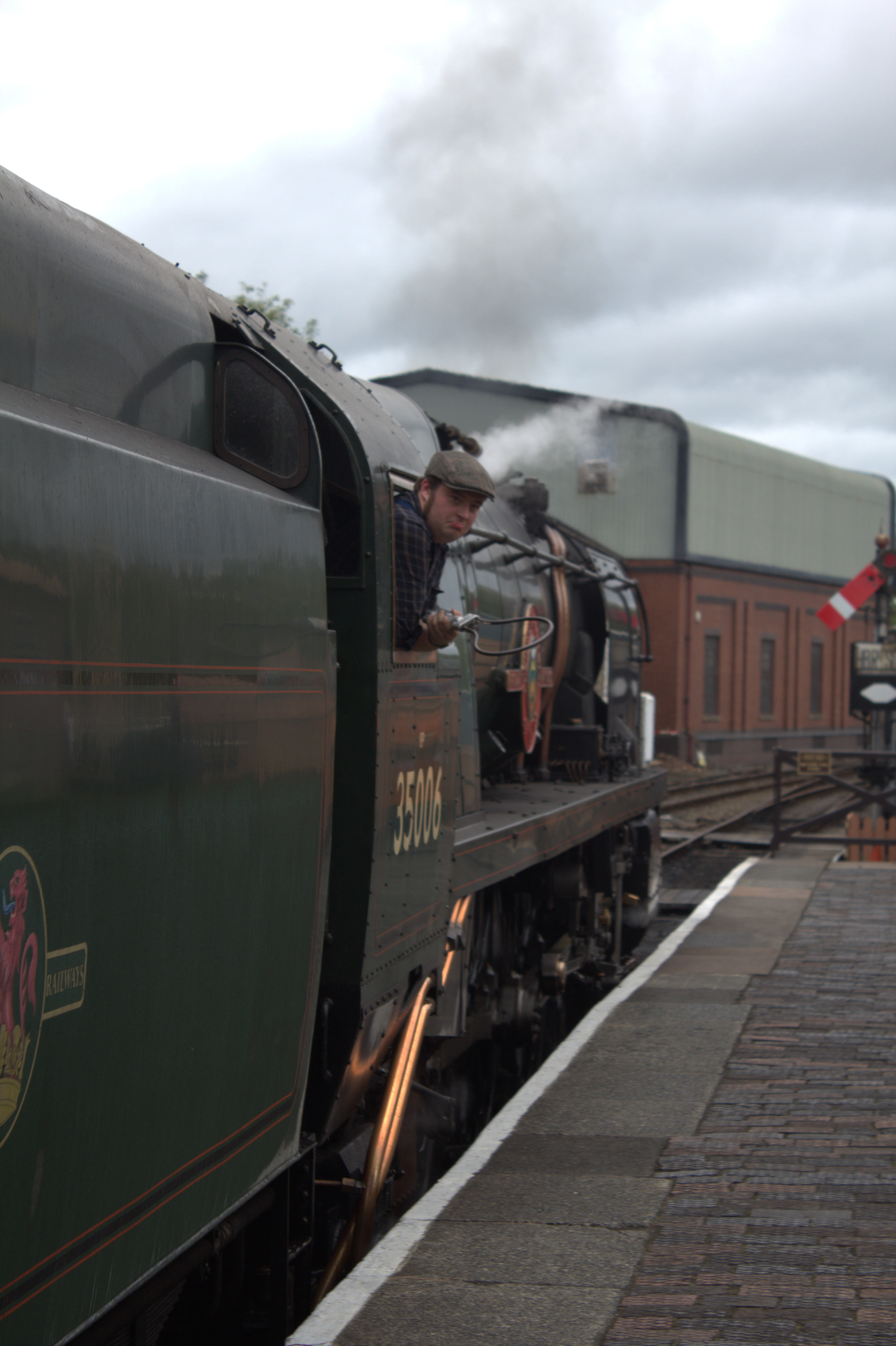 A guy hanging out of the cab of a train