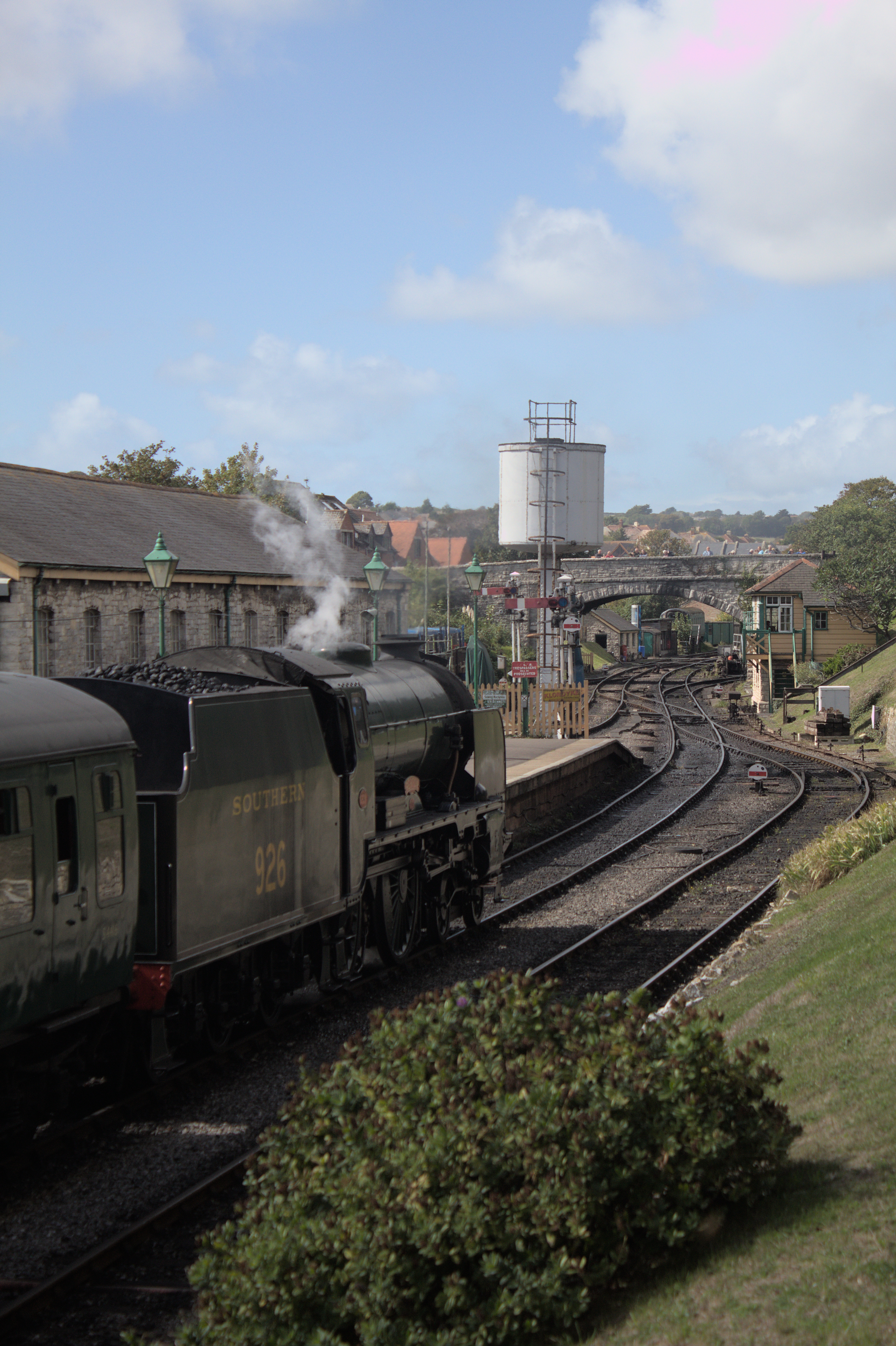 A steam locomotive pulling out of its station